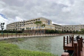 Ein mehrstöckiges Hotel mit Schwimmbad und Bootsanleger.