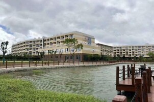 Un hotel de varios pisos con piscina y muelle.