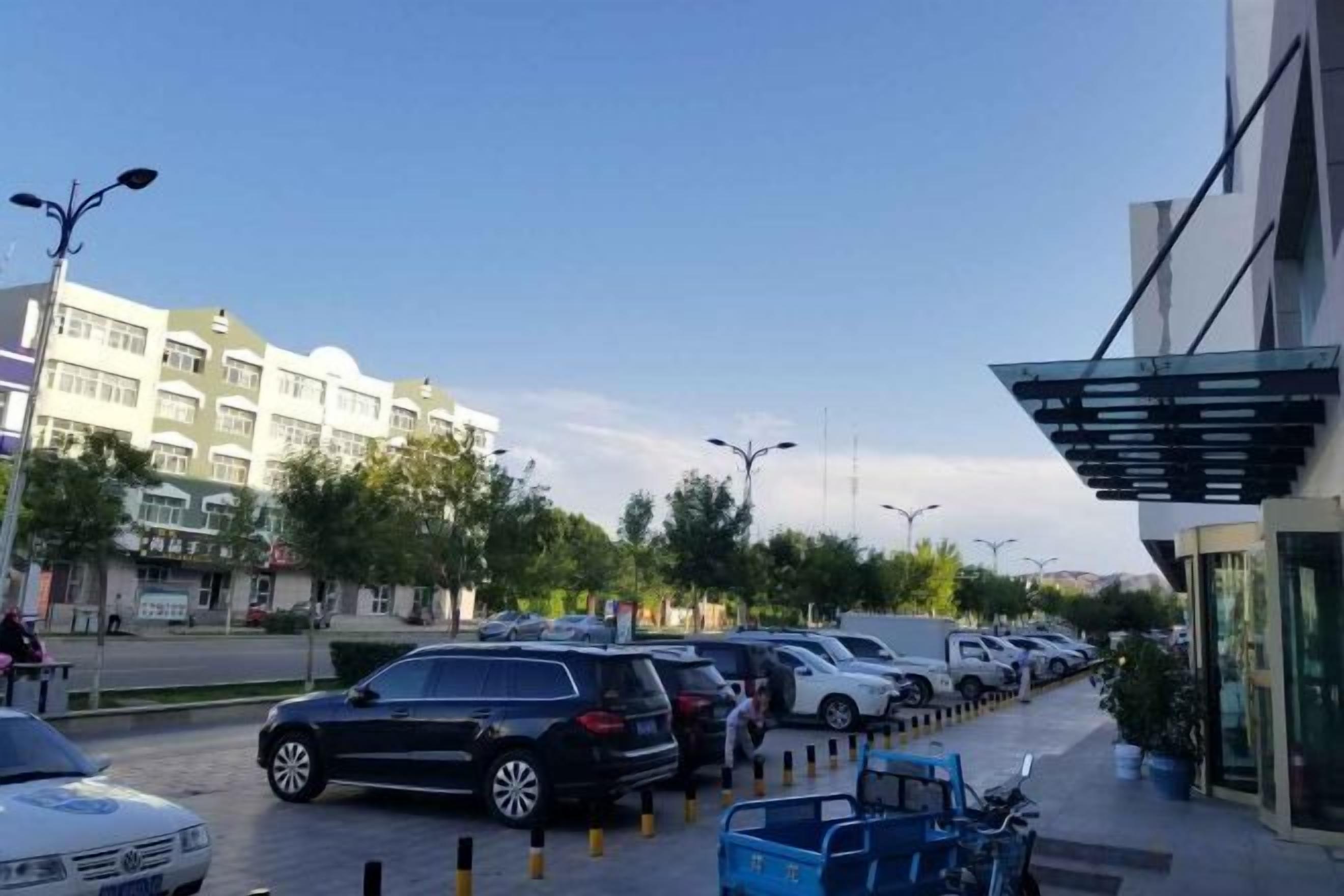 A parking lot with cars and a building with a modern design.