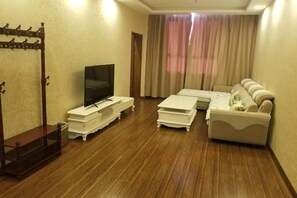A living room with a TV, sofa, and coffee table.