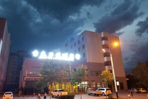 Un hotel de diseño moderno, con un letrero destacado y una entrada bien iluminada.