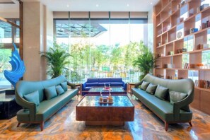 Un hall con un conjunto de sofás, una mesa de centro y una estantería.