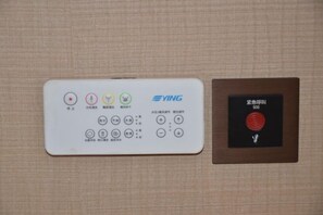 Et kontrolpanel med flere knapper og en rød nødbakke.