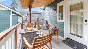 A covered outdoor patio with wooden furniture and a fire pit.