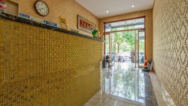 A reception area with a tiled wall, a clock, and a sign. - Qiqi Hotel (Taiyuan Zhenwu Road Wanmaqi Square) (Taiyuan)