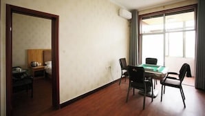 A room with a wooden floor, a green pool table, a bed with a wooden headboard, a small table with a lamp, and a window with curtains. - Qiqi Hotel (Taiyuan Zhenwu Road Wanmaqi Square) (Taiyuan)