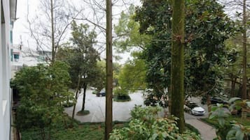 A residential area with trees, a pathway, and parked cars.