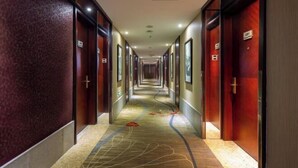 A long, narrow hotel corridor with doors on both sides, each marked with a number. - Tashan Hotel Pujiang (Pujiang)