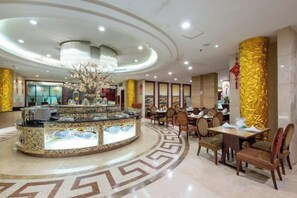 A hotel lobby with a central bar area, seating arrangements, and a decorative fountain. - Tashan Hotel Pujiang (Pujiang)