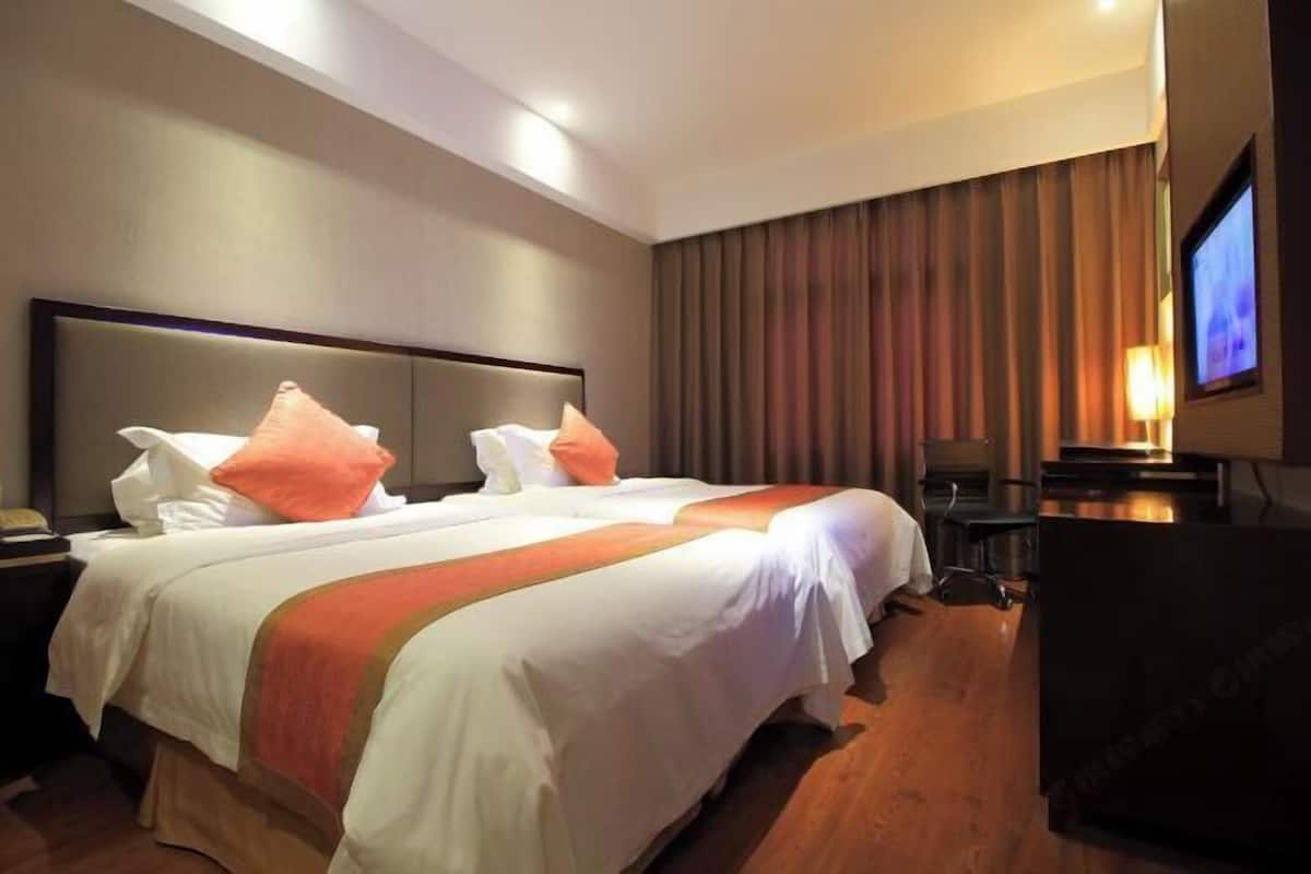 Une chambre d’hôtel avec un grand lit, une télévision et un bureau.