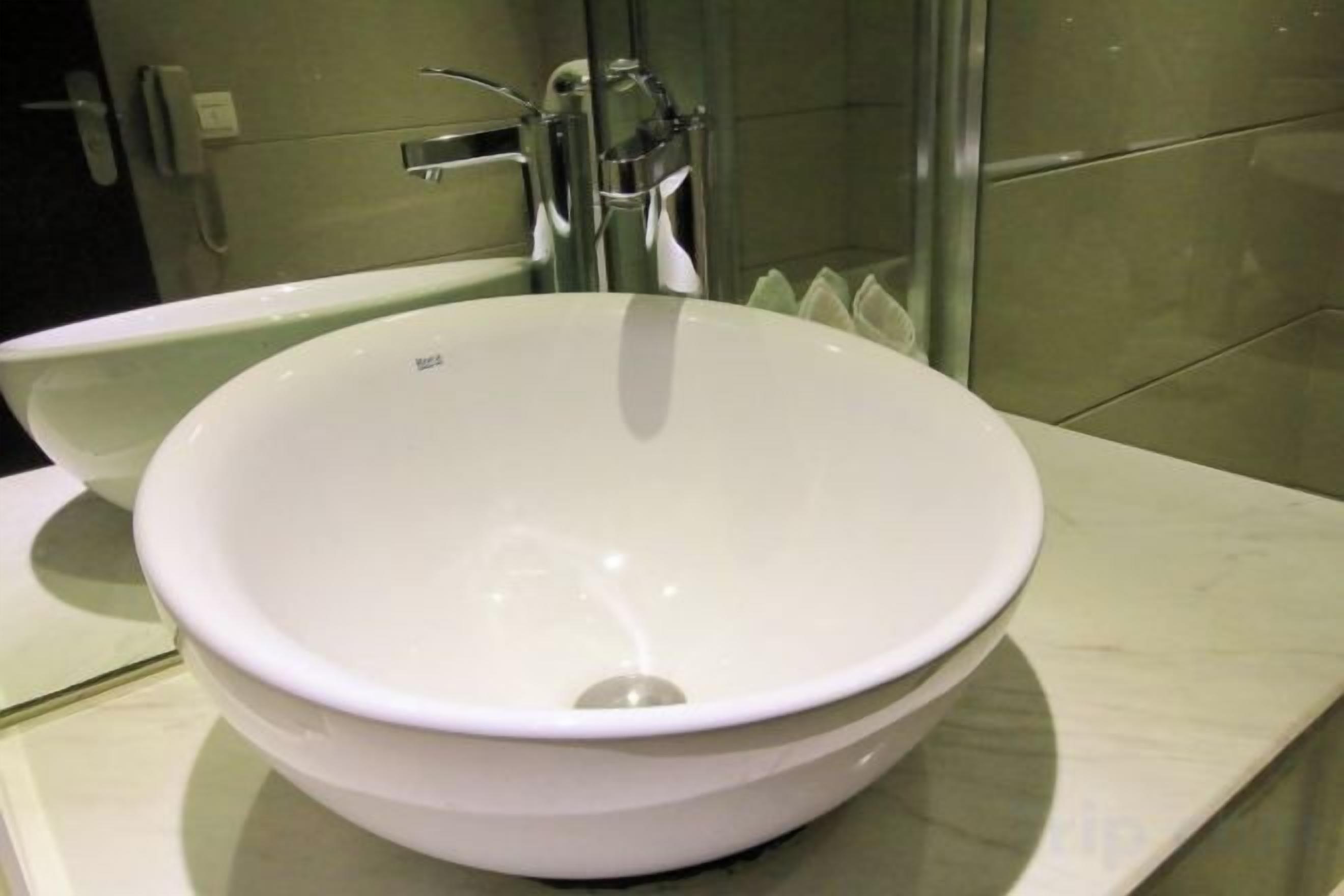 A white ceramic sink with a modern faucet in a bathroom.