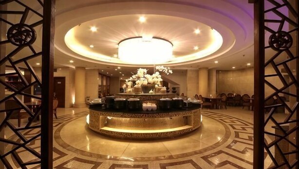 A lobby with a circular reception desk, a chandelier, and a patterned floor. - Tashan Hotel Pujiang (Pujiang)
