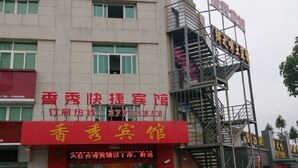 A hotel with a red sign and a staircase leading to an upper level. - Xiangxiu Hostel (Shanghai)