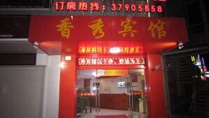 A hotel entrance with a red facade and glass doors. - Xiangxiu Hostel (Shanghai)