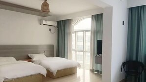 A hotel room with two beds, a TV, a chair, and a large window with curtains. - Xinyue Inn (Yueqing)