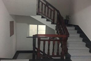 A staircase with wooden railings and a carpeted landing. - Xinyue Inn (Yueqing)