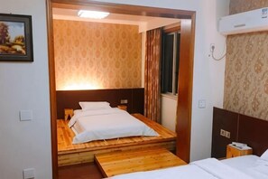 A room with a bed, a wooden platform, and a headboard. - Xinyue Inn (Yueqing)