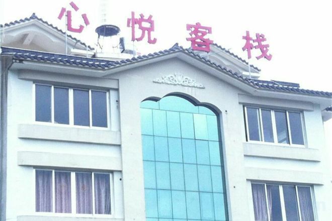 A building with a sign that reads '心悦客栈' and a large window.
