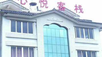 A building with a sign that reads '心悦客栈' and a large window.