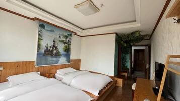 Habitación de hotel con dos camas, un televisor y un cuadro en la pared.