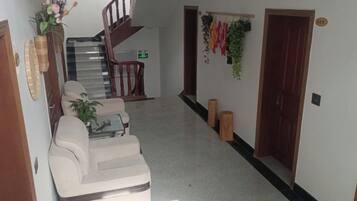 A hallway with a staircase, a sofa, and a coffee table.