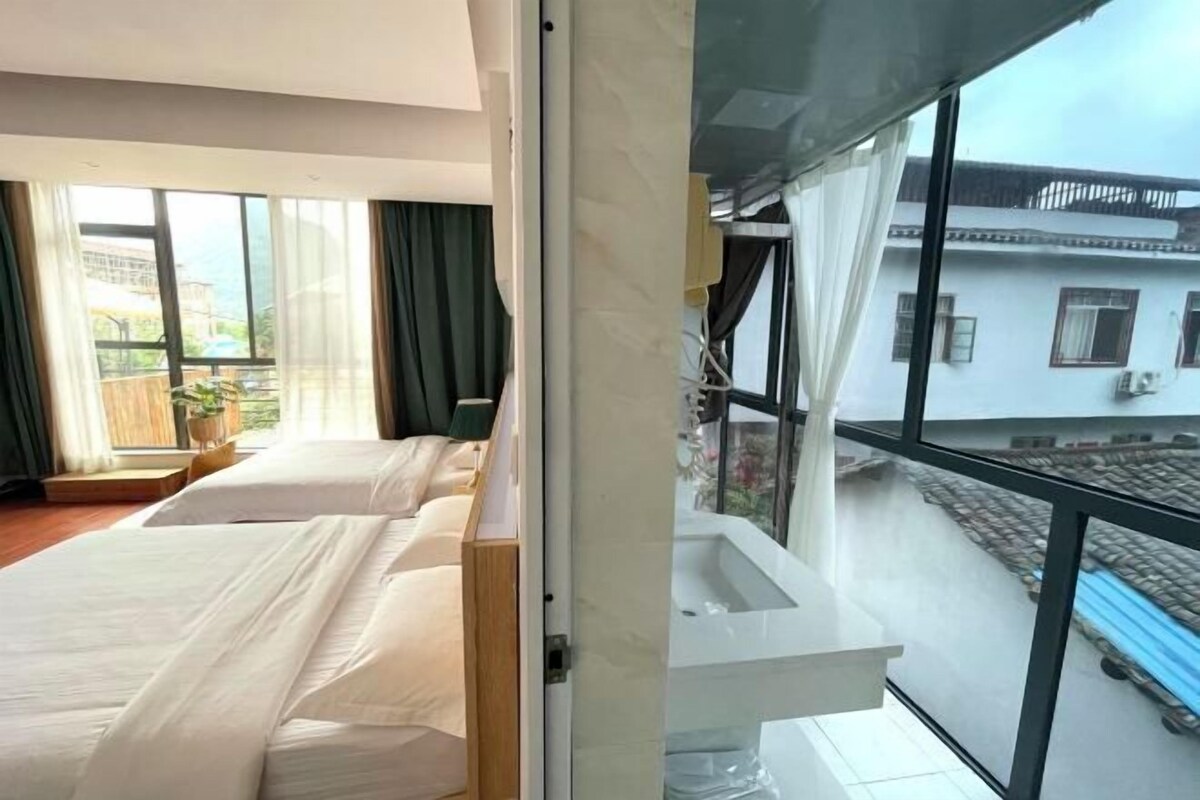 A hotel room with a large window, a balcony, and a view of the outside.