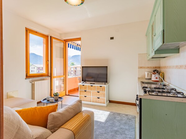 Een gezellig compact verblijf met een kitchenette, een bank, een televisie en uitzicht op de omgeving.