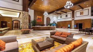 A spacious lobby with a checkered floor, wicker furniture, a reception desk, and a chandelier. - Kunming Jiali Ze Saville Royal Hotel (Songming)