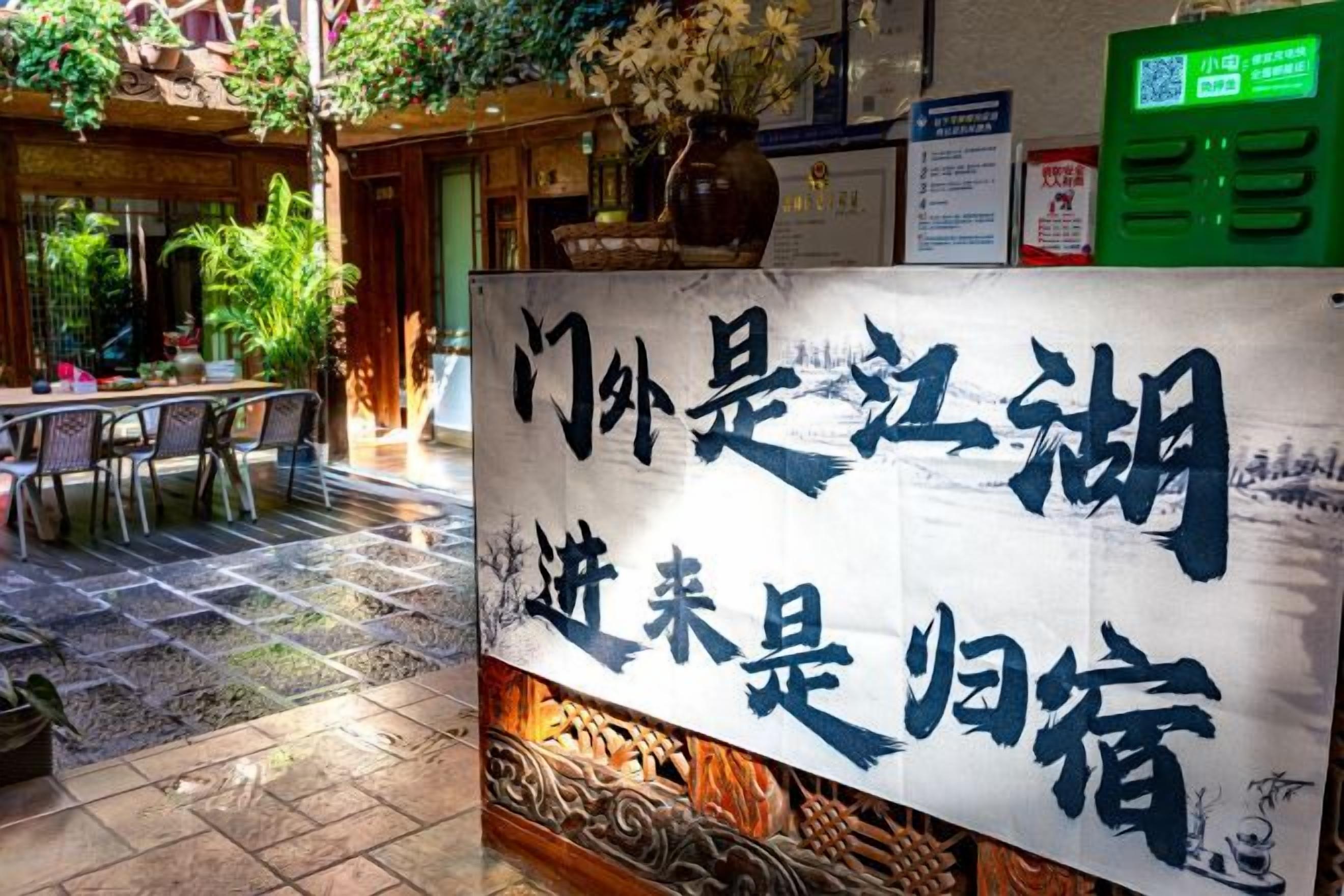 A traditional Chinese restaurant with a signboard, outdoor seating, and a tiled floor.