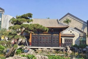 A traditional building with a tiled roof, a stone base, and a wooden gate. - Oushi Express Hotel (Guangzhou Lansha Lanhe) (Guangzhou)