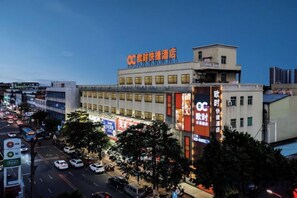 A hotel with multiple floors, a prominent sign, and a busy street in the foreground. - Oushi Express Hotel (Guangzhou Lansha Lanhe) (Guangzhou)