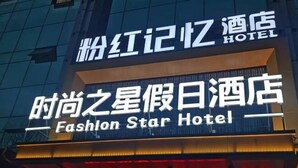 Das Außengelände des Fashion Star Hotels, wobei der Name sowohl in chinesischer als auch in englischer Schrift dargestellt ist.