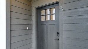 A dark gray door with a window and a keypad lock.