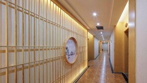 A corridor with a wooden wall and a circular artwork.