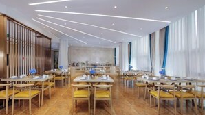 A spacious dining area with multiple tables and chairs, featuring a modern ceiling design with linear lighting.