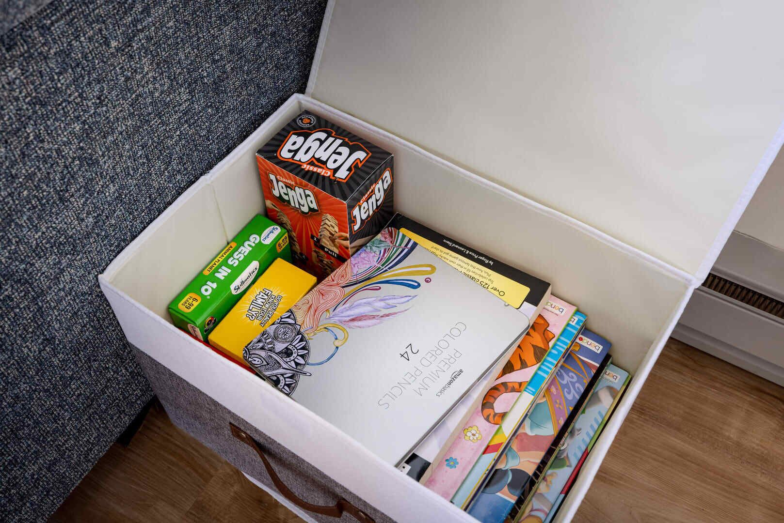 Een opbergdoos gevuld met verschillende kantoorartikelen, zoals notebooks, pennen en een doos potloden.
