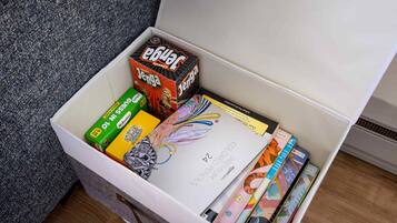 Een opbergdoos gevuld met verschillende kantoorartikelen, zoals notebooks, pennen en een doos potloden.