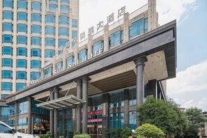 A hotel with a modern architectural design, featuring a prominent overhang and multiple floors. - Hualong Golden Key Hotel (Songxi)