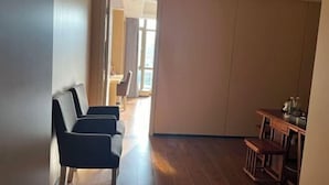 A hallway with a seating area, a wooden table, and a view into another room. - Hualong Golden Key Hotel (Songxi)