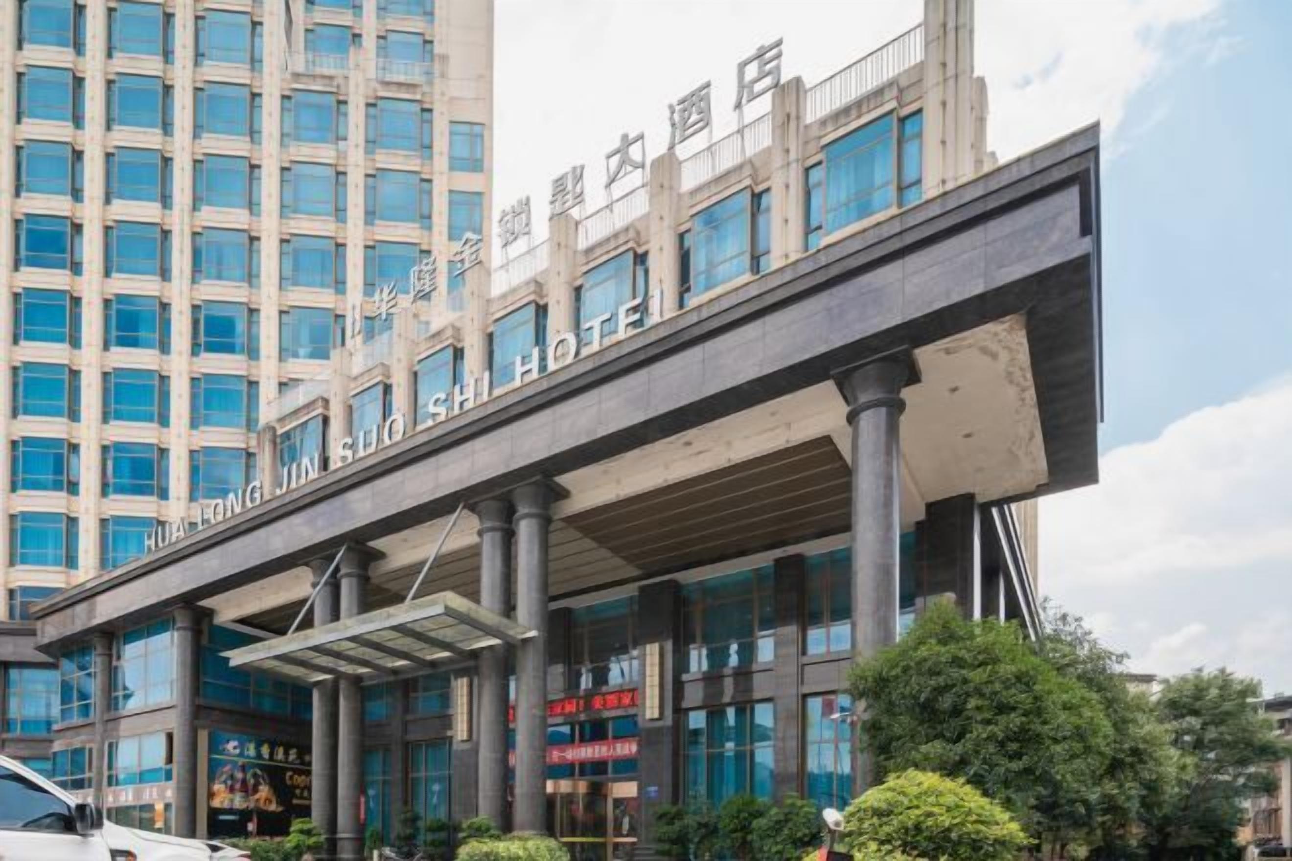 Un hotel con fachada moderna, amplios ventanales y zona de acceso cubierta.