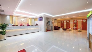 A modern hotel lobby with a reception desk, seating area, and a large window. - Red Lantern Traders Hotel (Nanning)