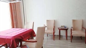 A room with a dining table, two chairs, a small round table, and a ceiling fan. - Pinyi Hotel (Hefei Fanhua Avenue Zhonghuancheng) (Hefei)
