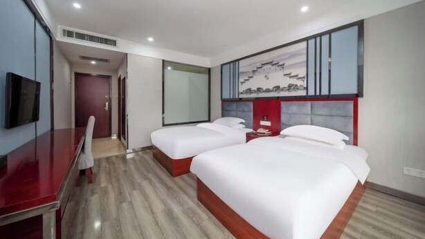 A hotel room with two beds, a desk, and a television. - Pinyi Hotel (Hefei Fanhua Avenue Zhonghuancheng) (Hefei)