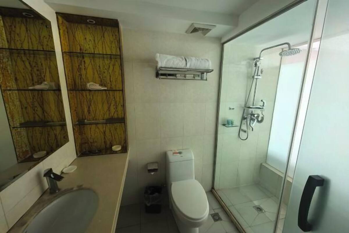 A bathroom with a bathtub, toilet, and glass-enclosed shower.