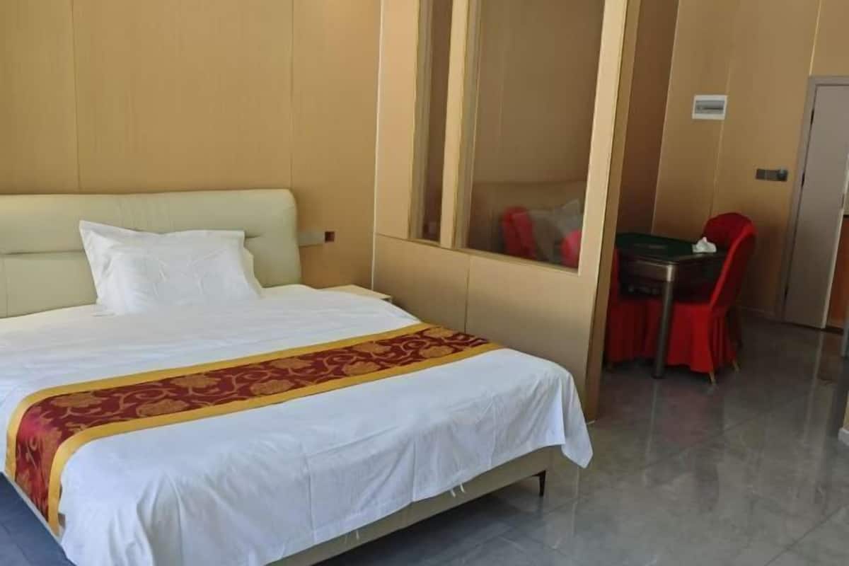 Ein Hotelzimmer mit einem Bett, einem kleinen Tisch mit Stuhl und einem Spiegel.