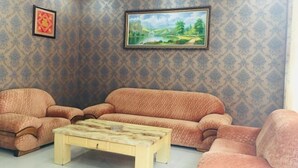A living room with patterned wallpaper, a sofa, two armchairs, and a coffee table. - Sheraton Pingli Hotel (Pingli)