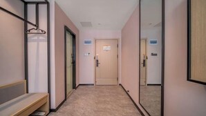 A hallway with a bench, a mirror, and a door with a sign. - IU Hotel (Chongqing Fengdu Ghost City) (Fengdu County)