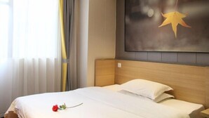 A hotel room with a bed, a large window with curtains, and a wall-mounted artwork of a star. - IU Hotel (Chongqing Fengdu Ghost City) (Fengdu County)