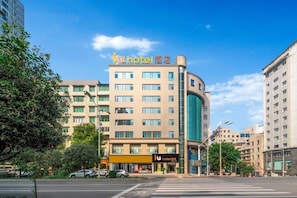 A hotel with a modern design, featuring a prominent 'iu hotel' sign, multiple floors, and a corner entrance. - IU Hotel (Fengdu County)