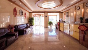 A spacious lobby with a reception desk, seating area, and decorative elements.